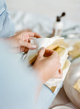Creative painter working with gold leaves