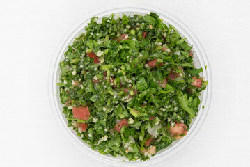Overhead view of tabouli salad presented in a clear bowl for a Mediterranean meal on the go