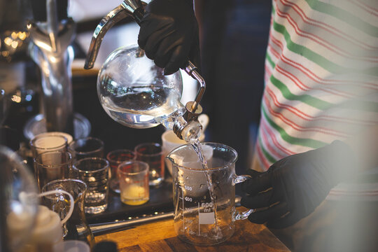 Select the focus glass container after distillation people pouring liquor Liquid in a glass jar in a lab Production and distillation