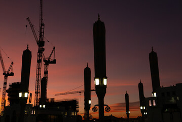 Silhouette of unopened giant canopies and construction cranes in the background in Medina, Kingdom of Saudi Arabia.