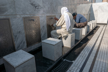 Unidentified Muslim men ready to take ablution outside Nabawi Mosque. This ritual purification is a...