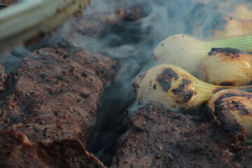 grilling some steak, and onions on the grill