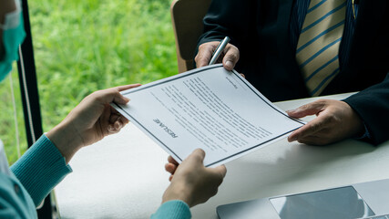 Young applicants who are serious about their work experience. and first impression in a modern office interview The recruiter will consider the resume. The HR manager will consider the employee's resu