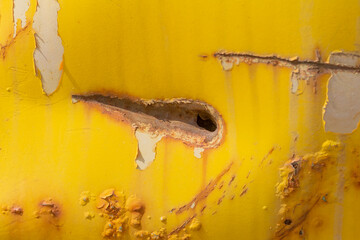 Rust.An old metal product with rust spots and fallen off yellow paint.