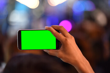 Hand holding mobile phone with chroma key screen