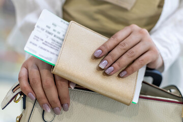 Closeup female tourist hands checking documents, passport and ticket get ready boarding at airport