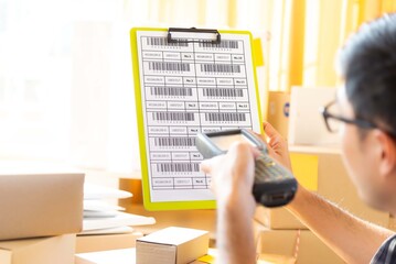Businessman check inventory with bluetooth barcode scanner in stock room. business online.