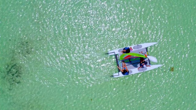 Small sailing catamaran on transparent waters of Juanillo beach, Dominican Republic. Aerial top-down