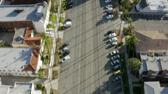 Aerial Panning Directly Above A Quiet City With A Tilt-Up To Reveal A Vast Urban Landscape With Cars, High-Rise Buildings, And Palm Trees - Glendale, California