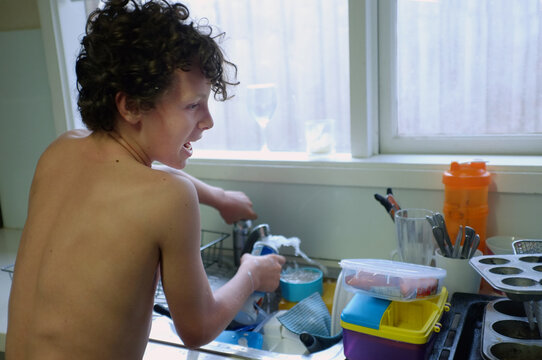 Chatty boy washing dishes