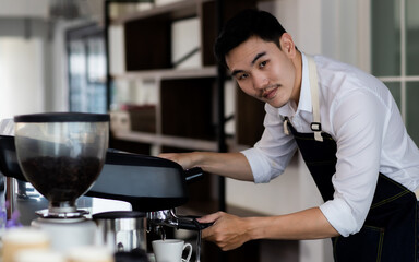 Fototapeta na wymiar Image of Silhouette. Asian young man using a coffee machine. Rinse the coffee with warm water. Asia man preparing for pressing ground coffee for brewing espresso or americano in a cafe.