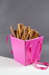 Pretty pink gift box with pet treats. Open box full of bully sti