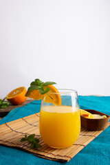 Jugo de naranja con decoración y frutas a su alrededor 