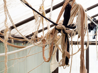 Many suspended chaotically intertwined ropes and ribbons of cloth tied into knots