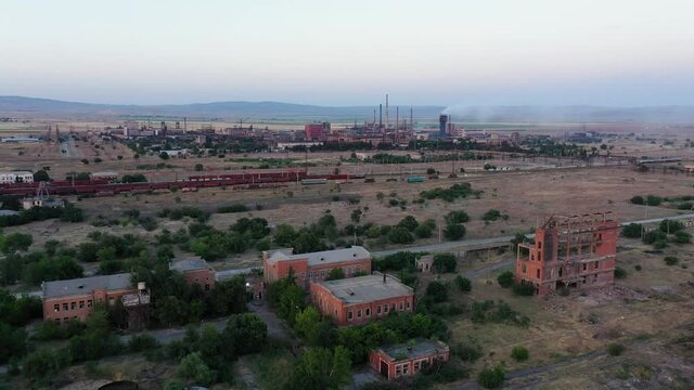 Distant View Of A Factory Manufacturing Nitrogen Based Fertilizers In Georgia With Ruins Of Building In Foreground. aerial