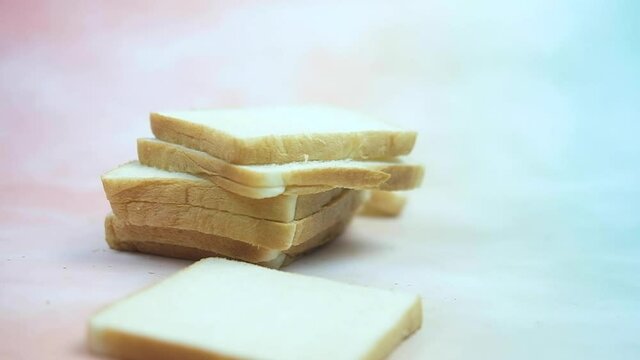 Slices of white bread falling on stock sliced bread. Shot of slow motion