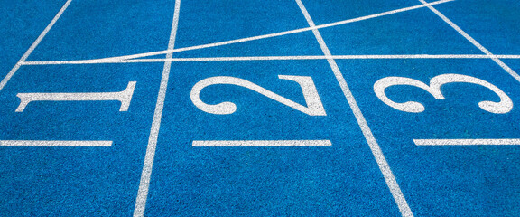 Blue running treadmill track with lane numbers in-stadium outdoors.banner image.