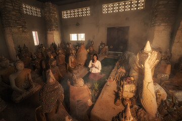 a woman praying in an ancient thailand temple , at 