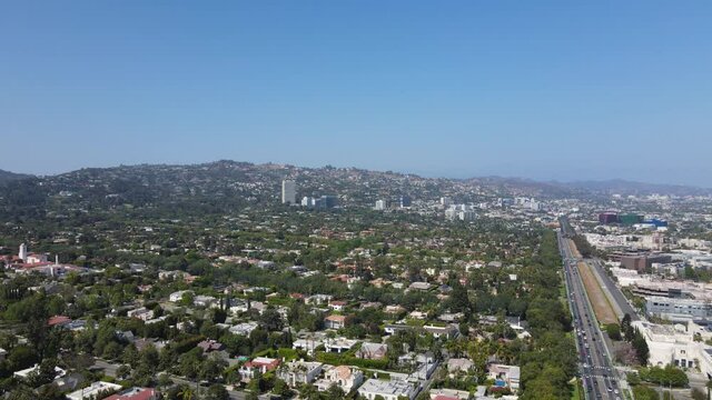 Beverly Hills, Los Angeles USA, Flying Above Upscale Residential Neighborhood on Sunny Day With Overview of Traffic on Santa Monica Boulevard, Drone Aerial View