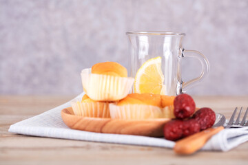 A glass with lemon and a snack on the side
