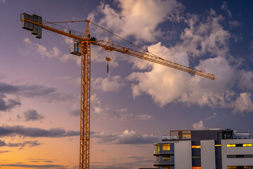 Construction crane near an apartment building at sunset, Brisbane, Australia - obrazy, fototapety, plakaty