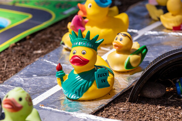 Hillsboro, Oregon \ USA - 05 May 2021: Yellow rubber duck in a green crown and green mantle with a torch and a book picturing  Statue of Liberty. Independence day theme