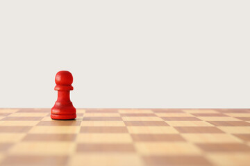 Red pawn on checkerboard against light background