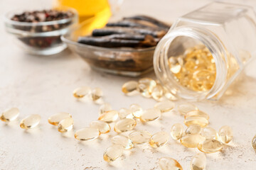 Fish with oil pills on light background