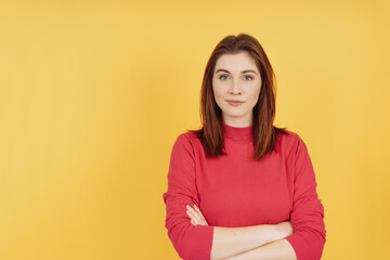 Obraz premium Calm confident young redhead woman with folded arms