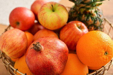 Basket with fresh fruits on wooden table, closeup