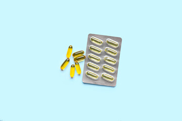 Blister package with fish oil capsules on color background