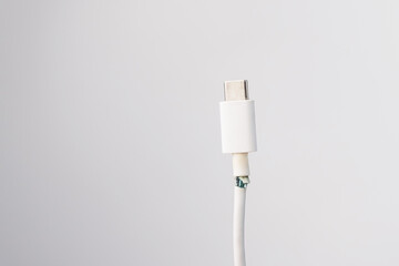 Torn cord for charging a mobile phone type si on a white background. Copy space.