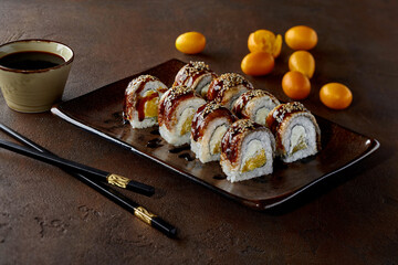 Sushi rolls with eel, cream cheese, orange, unagi sauce and sesame