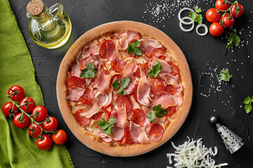 Top view of pizza with salami, bacon and smoked ham