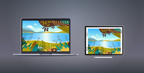 graphic tablet and laptop with beautiful landscape wallpapers on screens on gray background