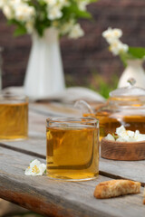 Green Chinese tea with jasmine in a mug with jasmine flowers.