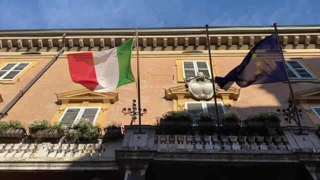 Italian and european flags waving in the wind on the balcony of government building. concept for tourism, patriotism, international business, policy, trade