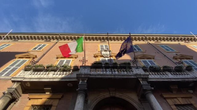 Italian and european flags waving in the wind on the balcony of government building. concept for tourism, patriotism, international business, policy, trade