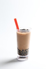 Taiwan popular black boba bubble milk tea with ice in tall glass pearl drink menu in white background with red straw 