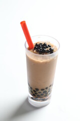 Taiwan popular black boba bubble milk tea with ice in tall glass pearl drink menu in white background with red straw 