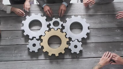 Business people connect golden gear together at meeting table, success cooperation teamwork concept