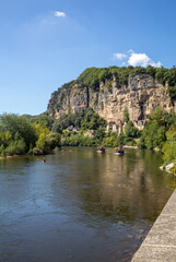 Fototapeta premium Canoeing and tourist boat, in French called gabare, on the river Dordogne at La Roque-Gageac, Aquitaine, France