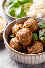 Traditional swedish meatballs with creamy sauce and mashed potatoes on gray table close up vertical photo