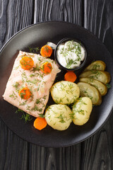 Inkokt Lax Recipe Swedish cold poached salmon with new potatoes closeup in the plate on the table. Vertical top view from above