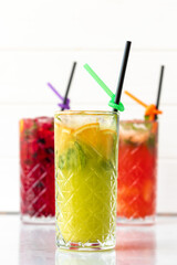 Three different refreshing lemonades on white wooden background