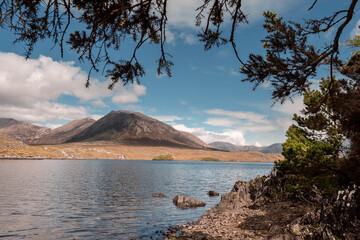 Lake Derryclare Lough in Connemara, county Galway, Ireland. Irish nature landscape. Beautiful scene with water, mountains and blue cloudy sky. Nobody. Popular tourist landmark