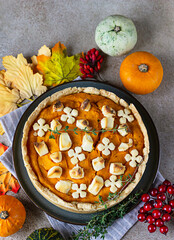 Top view of pumpkin tart or pie with feta cheese and thyme. Fall season concept. Cozy autumn food background.