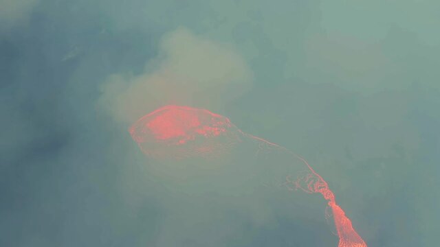 Aerial view around a volcano crater, in middle of thick sulfur smoke - orbit, drone shot