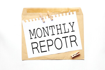 Monthly Report. text on white paper on craft notebook