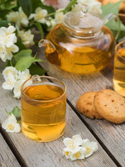 Green Chinese tea with jasmine in a mug with jasmine flowers.